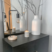 Pillar concrete candle burning on a dark console