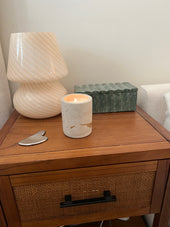 Pillar concrete candle burning on a wooden bedside table